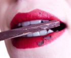 Smiling woman eating chocolate
